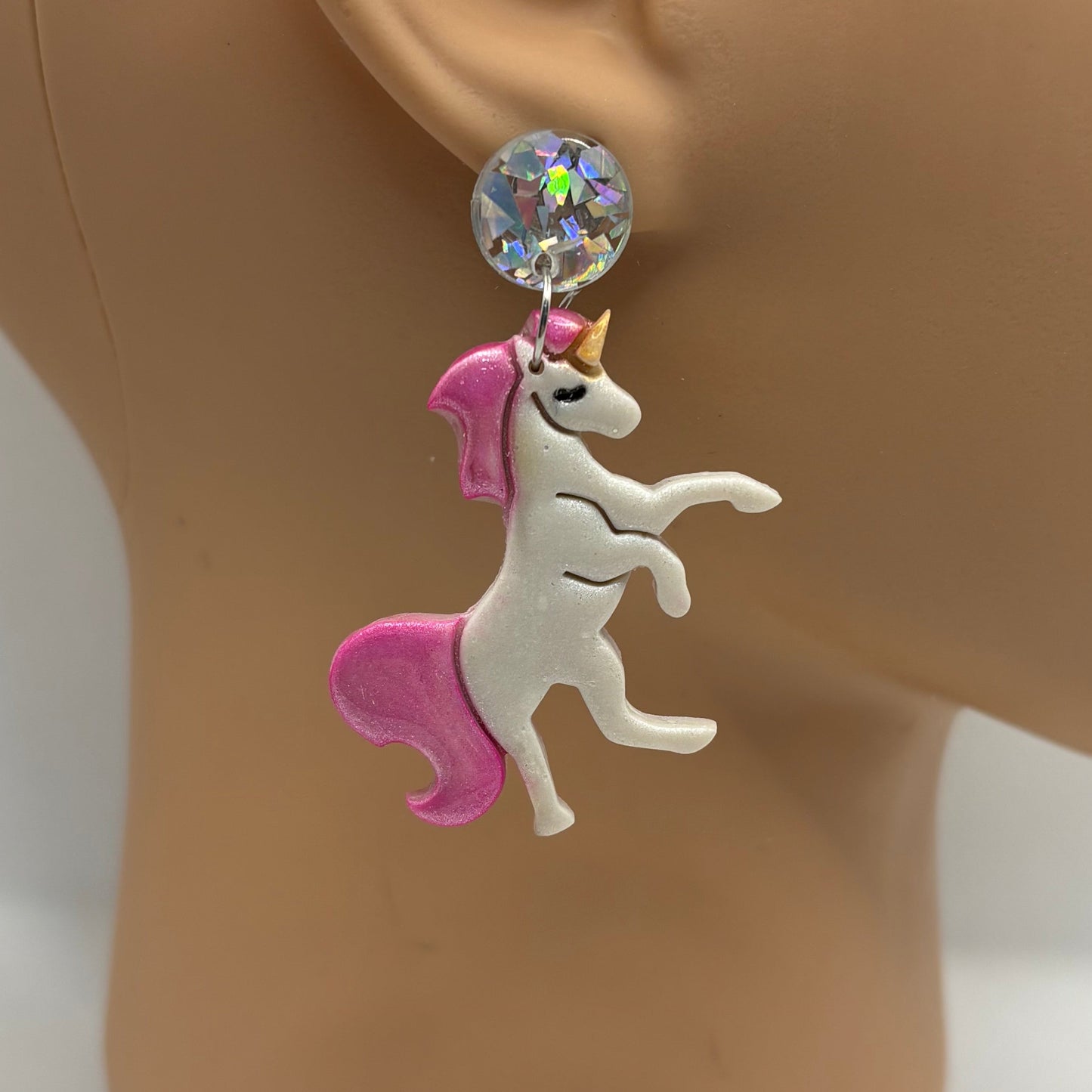 Earring on a mannequin ear with a white background